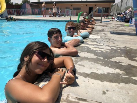 Students hang onto the edge of a pool.