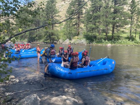 students with red helmets raft down the colorado river 
