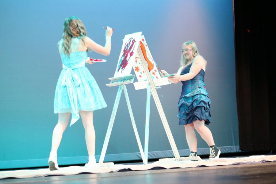 Girls+in+blue+dresses+fling+paint+on+stage.