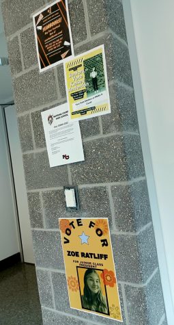 Student council posters hanging on gray concrete pillar in school